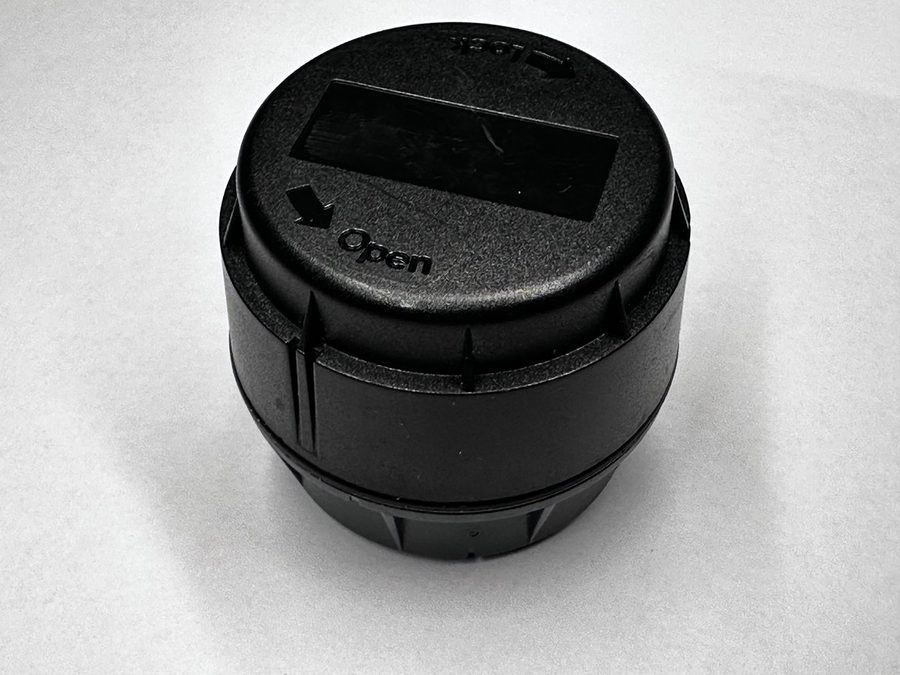 The closed puck showing the molded Open and Lock arrows