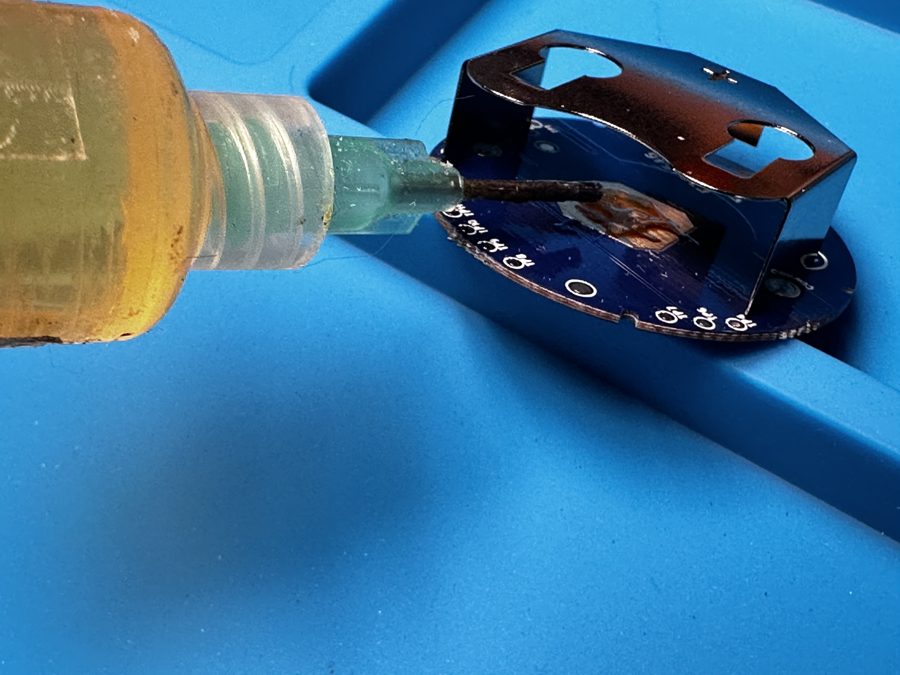 Applying flux to the XA122's bare copper center battery pad